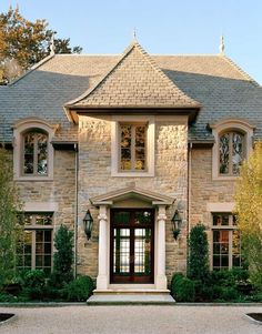 a large brick house with two story windows and an entry way leading to the front door