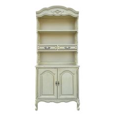 an antique white china cabinet with two doors