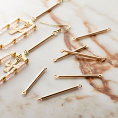 several gold and pink beaded earrings on a marble surface