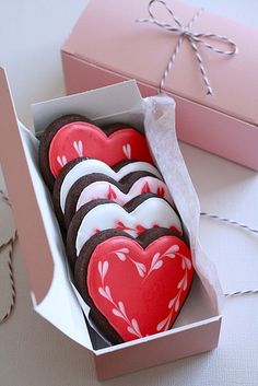 a box filled with heart shaped cookies on top of a table