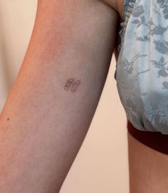 a woman's arm with a small tattoo on the left side of her body