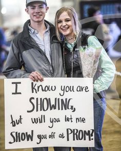 a man and woman holding a sign that says i know you are showing but will you let me show you off at prom?