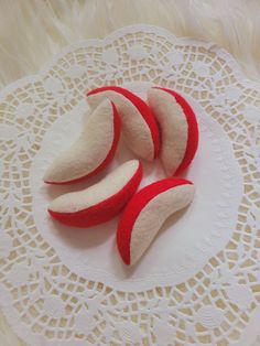 three red and white pieces of fruit on a doily