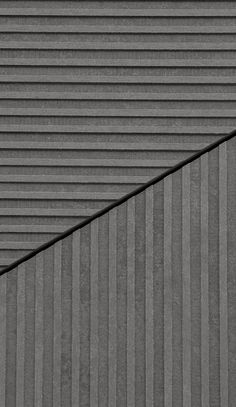 a black and white photo of the side of a building with vertical lines on it