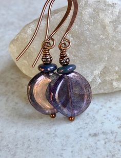 "blue purple czech glass earrings copper boho earrings dangle These round-ish discs are transparent Czech glass with a blue-purple coating - their color changes as the light changes. Sitting on each one is an opaque blue-purple glass disc and a tiny antiqued copper bead. Hook ear wires are antiqued copper plated brass. Length of earrings from top of ear wires is 1 5/8\". Glass discs measure 14mm, about 1/2\". You can enter my shop here: gypsydangles.etsy.com" Purple Czech Glass Earrings With Dangling Beads, Blue Czech Glass Earrings With Dangling Beads, Victorian Earrings Antiques, Bohemian Purple Earrings With Czech Glass, Nickel-free Purple Beaded Earrings From Czech Glass, Nickel-free Purple Czech Glass Beaded Earrings, Art Deco Earrings, Purple Glass, Antique Earrings