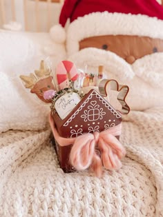 a gingerbread house is wrapped in pink ribbon and surrounded by candy, candies, and other holiday decorations