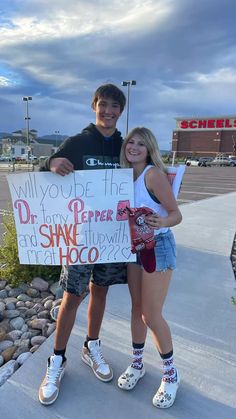 two people standing next to each other holding a sign that says, will you be the dr pepper shaker?