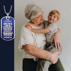 an older woman holding a young boy in front of a dog tag with the words grandson on it