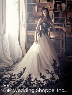 a woman in a wedding dress standing by a window