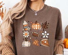 Experience the essence of autumn with our exclusive fall favorites shirt. This cozy and stylish tee showcases beloved seasonal elements, including delicious pumpkin pie, the thrill of football, and the vibrant colors of fall leaves. Perfect for those crisp days spent enjoying the outdoors or gathering with friends and family, this shirt lets you celebrate the season in comfort and style. Crafted from soft, breathable fabric, it provides an ideal fit for any occasion. Whether you're heading to a football game, enjoying a pumpkin-spiced latte, or taking a stroll through a kaleidoscope of fall colors, this shirt is a must-have addition to your wardrobe. Embrace the warmth and joy of fall--get yours today! Colors Of Fall, Friends Gathering, Delicious Pumpkin, A Football, Fall Favorites, Football Game, Pumpkin Spice Latte, Fall Leaves, Favorite Shirts