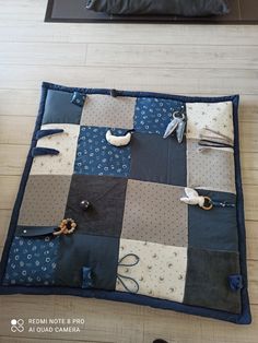 a blue and white patchwork quilt on the floor