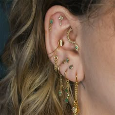 a close up of a person's ear with gold jewelry on top of it