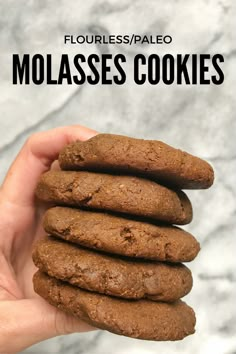 a hand holding a stack of molassses cookies