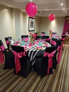 a banquet room set up for a party with pink and black decorations on the tables