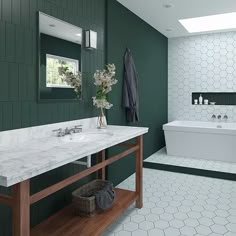 a bathroom with green walls and marble counter tops, along with a white bathtub