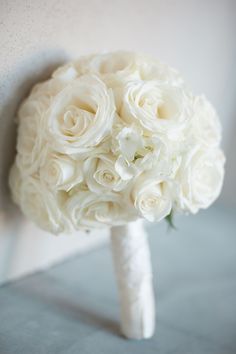 a bridal bouquet with white roses on it