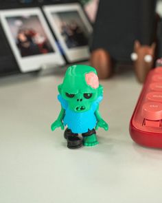 a small toy is sitting next to a computer keyboard on a white table with other toys in the background