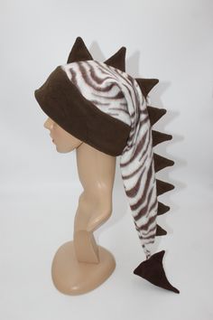 This listing is for the hat pictured, you will receive this exact hat.   With its eye-catching pattern and long row of spikes, everyone you encounter will wonder where you got such a great hat and will want one for themselves! Hat is sized to fit any ages from 4 years old and up- fits kids, adults, and teens alike. Extra stretchy, wonderfully warm band with ear flaps make this hat perfect for anyone! Feel free to ask for a custom sized hat, we will make one in any mix of colors/patterns, sized j Adjustable Beanie Costume Hat For Winter, Adjustable Warm Winter Costume Hats And Headpieces, Adjustable Beanie For Winter, Winter Novelty Adjustable Costume Hats, Novelty Adjustable Winter Hat, Winter Novelty Hats Adjustable, Dinosaur Tails, Dinosaur Hat, Silly Clothes