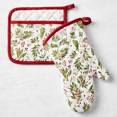 two oven mitts are sitting next to each other on a white counter top with red trimmings