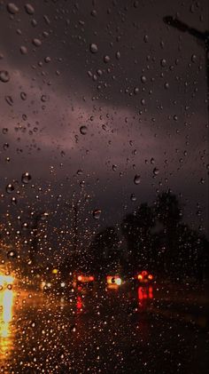 rain drops on the windshield of a car at night