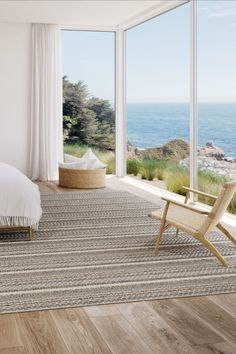 a bedroom with a large window overlooking the ocean