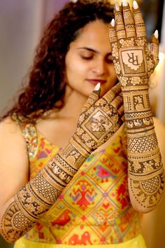 a woman holding her hands up to show the hendi