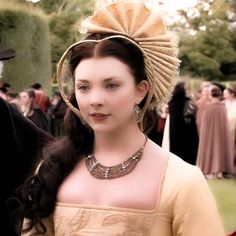 a woman in an old fashion dress and headpiece standing next to a man wearing a top hat