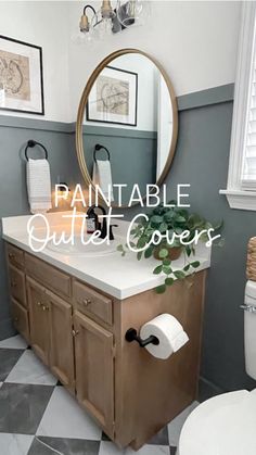 a white toilet sitting next to a bathroom sink under a round mirror on top of a wooden cabinet