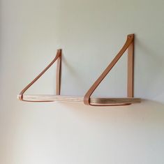 two wooden shelves are hanging on the wall