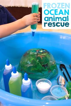 a child is playing with an ocean animal rescue kit in a blue plastic tub filled with water