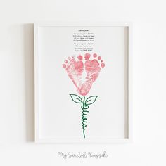 a handprinted rose is displayed in a white frame