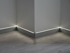 the corner of a room with two lights on each side and one light at the end