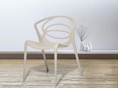 a white plastic chair sitting on top of a hard wood floor next to a wall