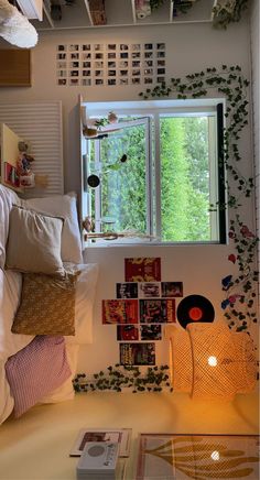 a bed with pillows and pictures hanging on the wall next to a window in a bedroom