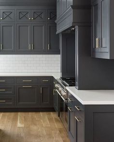 a kitchen with black cabinets and white counter tops