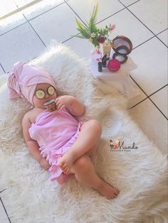 a baby is laying on a white rug