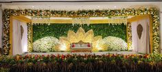 the stage is decorated with flowers and greenery