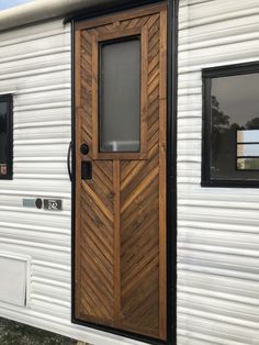 a white trailer with a wooden door and windows