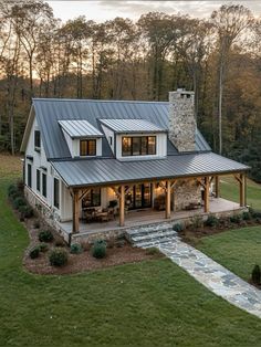 a house with a metal roof and stone chimney