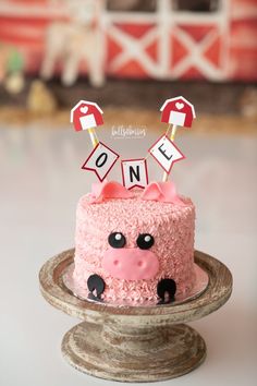 a cake decorated with pink frosting and an animal on top is sitting on a table