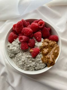 a bowl filled with oatmeal, raspberries and peanut butter