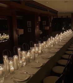 a long table is set with candles and place settings for dinner guests to sit at