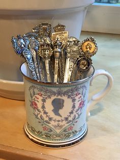 a cup filled with lots of silver spoons on top of a counter