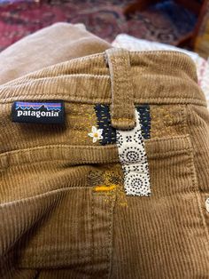 a pair of brown cordon pants with patches on the side and a tag that says patagonia