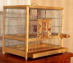 a bird cage sitting on top of a wooden table