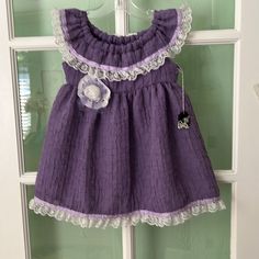 New Purple Handmade Sleeveless Dress. Lace And Ribbon Have Been Sewn Around The Ruffle On The Neck And Hem. A Handmade Lace Rose Has Been Added To The Front Of The Dress. Purple Sleeveless Dress For Spring Dress-up, Cute Sleeveless Sundress With Lace Trim, Purple Sleeveless Dress For Dress-up, Cute Sleeveless Dress With Lace Trim, Cute Purple Sleeveless Dress, Sleeveless Ruffled Sundress For Dress-up, Sleeveless Ruffled Dress For Dress-up, Cute Purple Sleeveless Sundress, Cotton Sleeveless Sundress For Babies