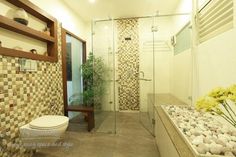 a bathroom with a toilet, shower and flower arrangement on the counter top in front of it