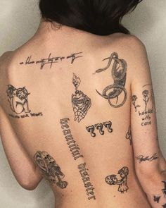 the back of a woman's body with tattoos on it