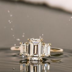 a three stone diamond ring floating on water