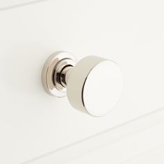 a close up of a knob on a white cabinet